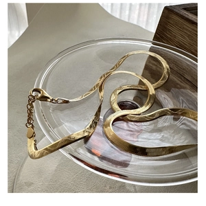 Detail of gold snake chain necklace with lobster clasp and adjustable link chain