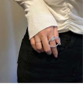 Macro view of modern S925 sterling silver multilayer wrap ring and minimalist band on model