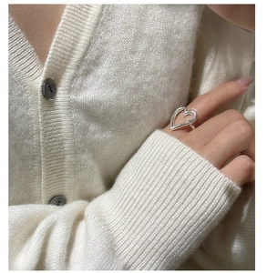 Close-up of S925 sterling silver hollow heart ring worn on a finger for a minimalist style