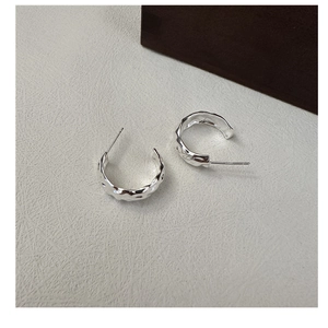 Détail des boucles d'oreilles S925 argentées en forme de C avec texture martelée