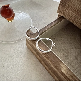 Close-up of S925 sterling silver hoop earrings with visible metal hallmark engraving