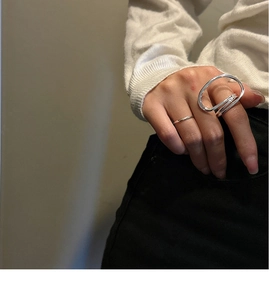 Detail of minimalist silver stackable rings featuring an abstract oval double layer design