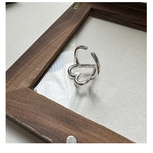 Macro detail of S925 sterling silver hollow heart ring with adjustable open band design
