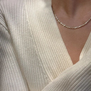 Gros plan d'un délicat collier en argent sterling S925 avec pendentifs irréguliers