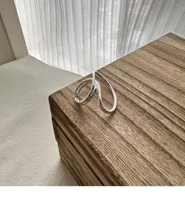 Close-up of polished S925 sterling silver ring with minimalist twisted double lines