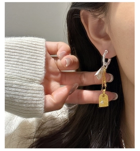Macro view of S925 silver vintage earrings with gold-toned embossed pendant and zircon