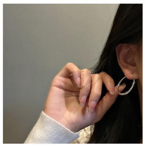 Close-up of minimalist S925 sterling silver hoop earring worn on a model's ear lobe
