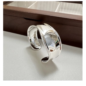Close-up of polished S925 sterling silver cuff bracelet with irregular wavy design
