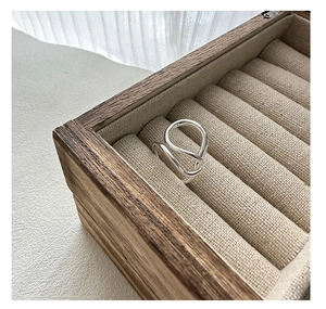 Macro detail of a minimalist S925 sterling silver ring with a twisted streamline design