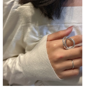 Detail of S925 sterling silver hollow cross ring and minimalist band on model