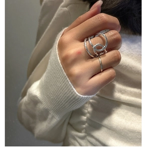 Nahaufnahme eines minimalistischen S925 Sterlingsilber Knoteny-Ring-Sets an der Hand