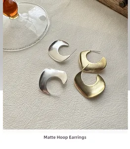 Detail view of gold and silver matte S925 sterling silver crescent hook earrings