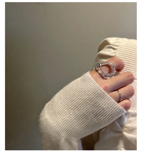 Detail of minimalist S925 sterling silver twisted geometric ring styled on finger