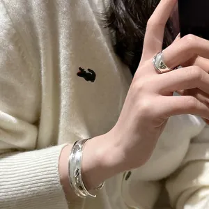 Polished S925 sterling silver curved ring and matching cuff bracelet on model