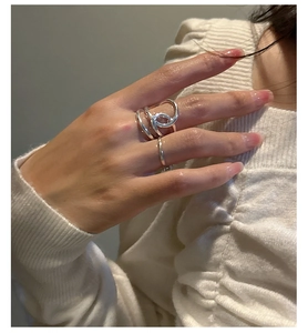Detailaufnahme eines minimalistischen S925-Silberknotenrings an einer Hand mit weichem Licht