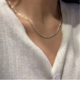Détail d'un collier en argent sterling S925 scintillant porté par un mannequin en blanc