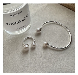 Macro detail of S925 sterling silver hammered texture ring and bracelet with pearls