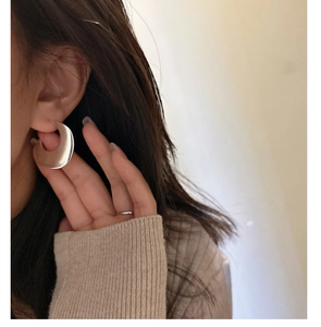 Close-up of matte silver S925 sterling silver hoop earrings with brushed metal texture