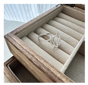 Close-up of minimalist S925 silver layered twisted ring on a rustic wooden jewelry box