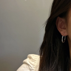 Minimalist S925 sterling silver hoop earrings shown on model for a sleek daily look