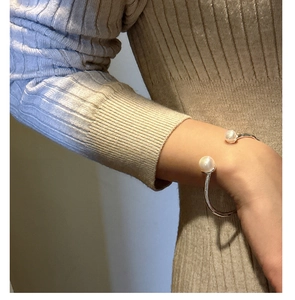 Detail of S925 silver cuff bracelet featuring two large glossy white pearls on wrist