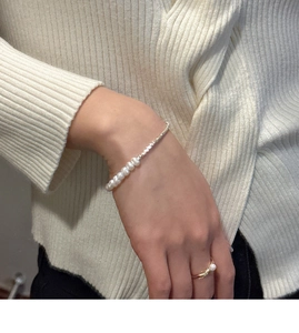 Detail shot of minimalist S925 silver pearl necklace and ring set on white sweater