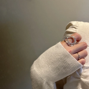 Minimalist S925 sterling silver ring with irregular fluid lines on a model's hand