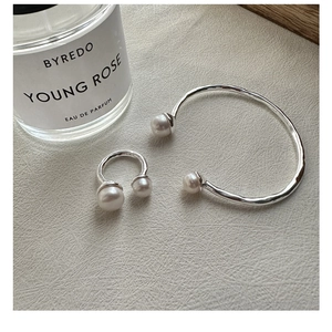 Detailed close-up of textured S925 sterling silver bangle and ring set with pearls