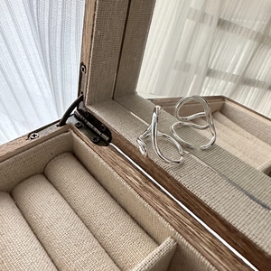 Minimalist S925 silver wavy rings displayed on a wooden jewelry box with soft light