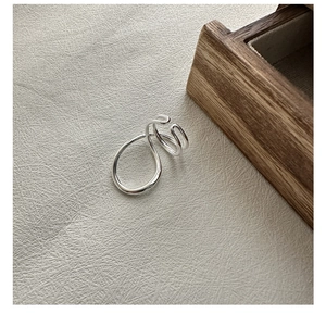 Detail of minimalist S925 sterling silver ring with liquid metal flowing line design