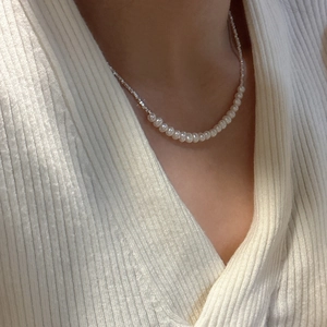 S925 sterling silver pearl necklace with silver beads on a model wearing a striped sweater