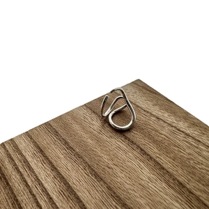 Minimalist S925 sterling silver irregular flowing line ring on a textured wood block