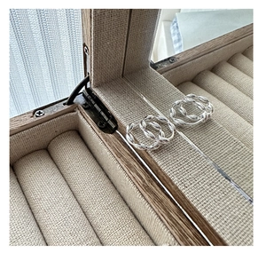 Close-up of S925 sterling silver twisted hoop earrings in a linen jewelry box