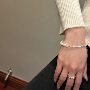 Detail of minimalist S925 silver necklace with white pearls on a female model