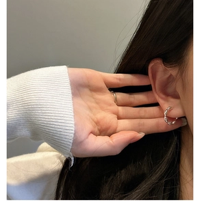 Close-up of S925 sterling silver wavy hoop earrings on a model for a chic style