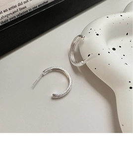 Detailed view of S925 sterling silver C-shape earrings with frosted matte texture finish