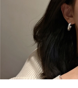 Detail view of S925 sterling silver C-shape stud earrings with brushed matte texture