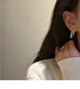Detail showing S925 silver star earrings and a delicate gold ring with a single white pearl