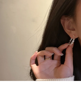 Detailed view of silver star hoop earrings worn by a model in a lifestyle setting