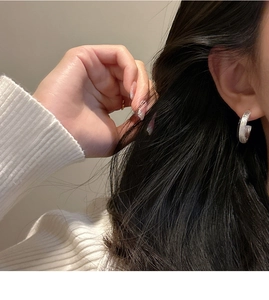 Close-up of S925 sterling silver C-shaped stud earrings with brushed texture on model