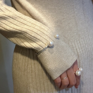 S925 sterling silver open pearl bracelet and ring set for women on a knit background