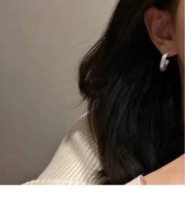 Close-up of S925 sterling silver C-shape earring with brushed matte texture on model ear