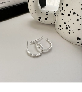 Detailed close-up of S925 sterling silver hoop earrings with embossed star pattern design