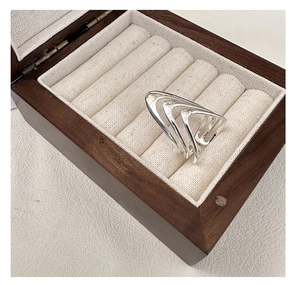 Macro shot of silver multi-layered V-shaped geometric ring on jewelry box liner
