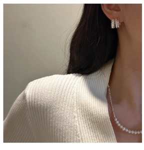 Gros plan de boucles d'oreilles torsadées triple couche en argent S925 sur modèle