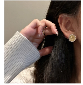 Close-up of S925 silver and gold tone coin earrings with royal portrait relief