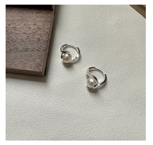 Détail de boucles d'oreilles créoles torsadées en argent avec perles élégantes