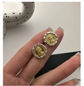 Macro shot of S925 silver coin earring with a gold portrait relief and hammered texture