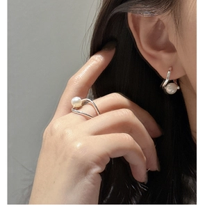 Détail d'un ensemble bague et boucle d'oreille en argent S925 avec perles au design ondulé