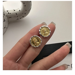 Detailed shot of two-tone S925 silver coin earrings featuring an embossed portrait